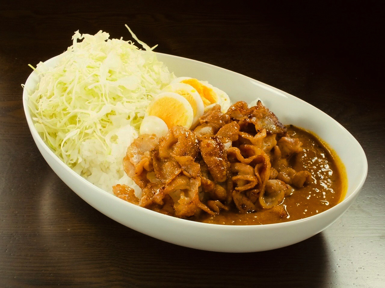 一番人気のぐるまんカレー。特製豚バラ肉とゆで卵がトッピングしてあります。キャベツはお替り自由です。