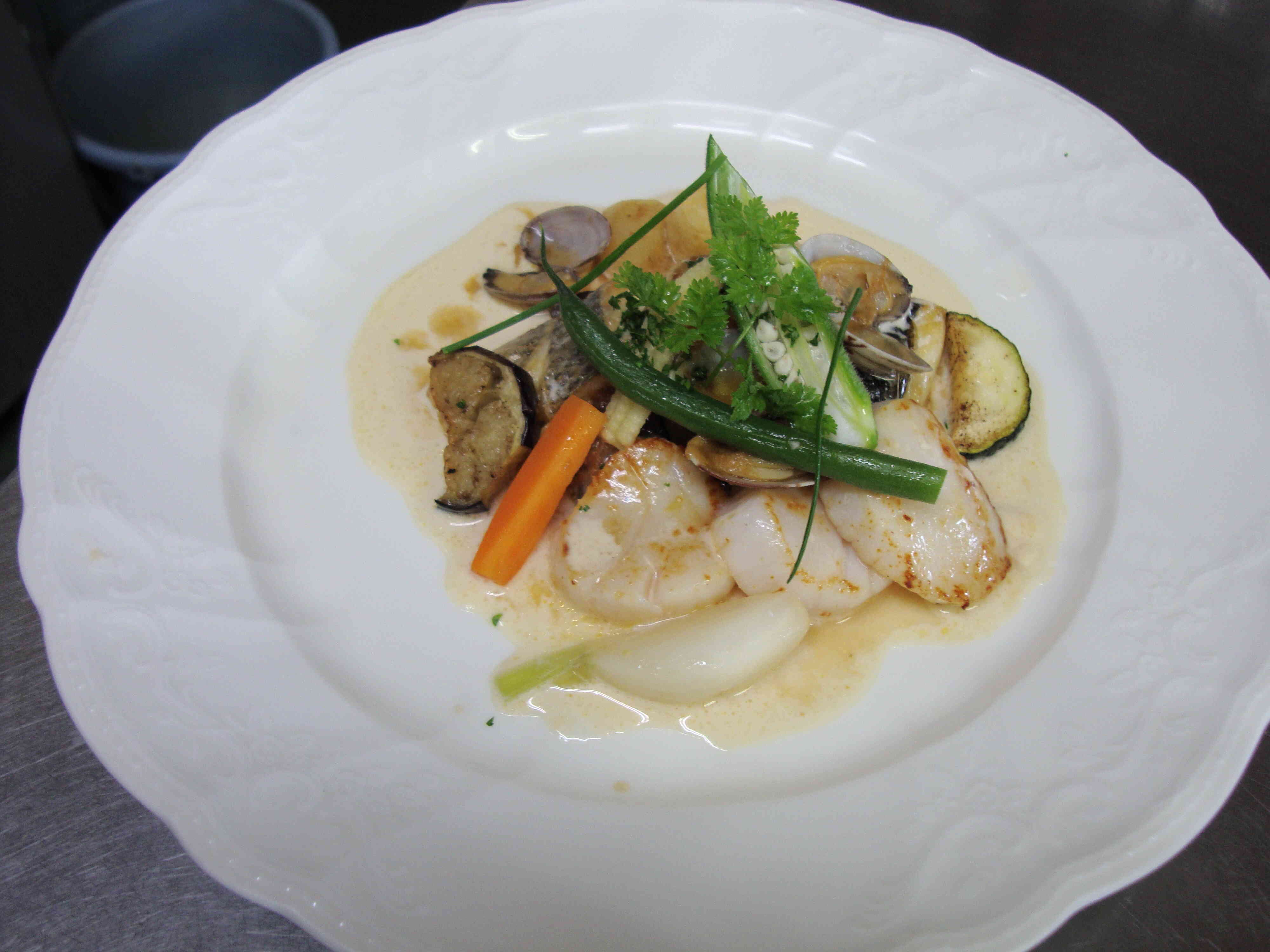 白身魚と帆立貝のクリームソース(市場で仕入れた鮮度のいい白身魚・帆立貝をポワレして野菜と魚のあらを詰めたクリームソースで提供しています)

