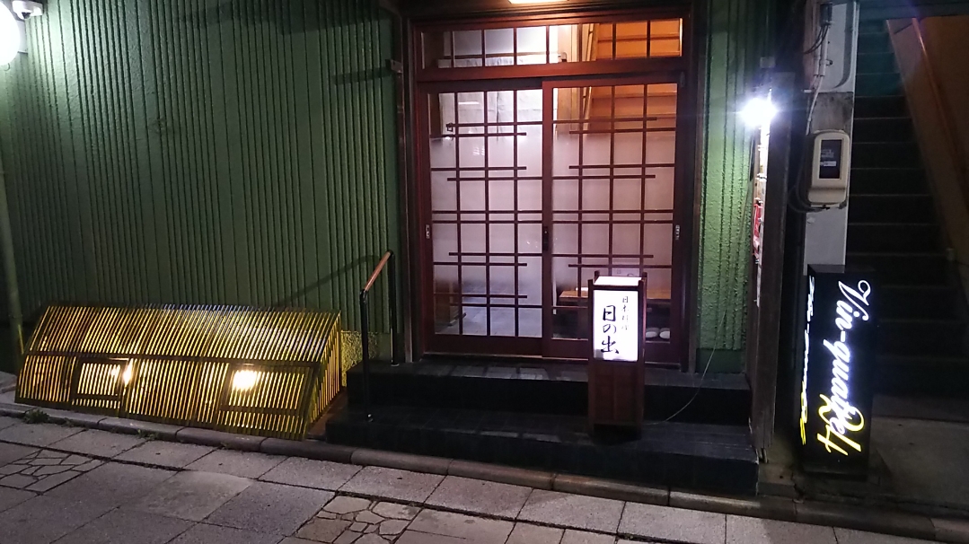 夜間の外観：照明付きの犬矢来・行灯を備えた玄関です。外壁は薄いグリーン色になっております。
