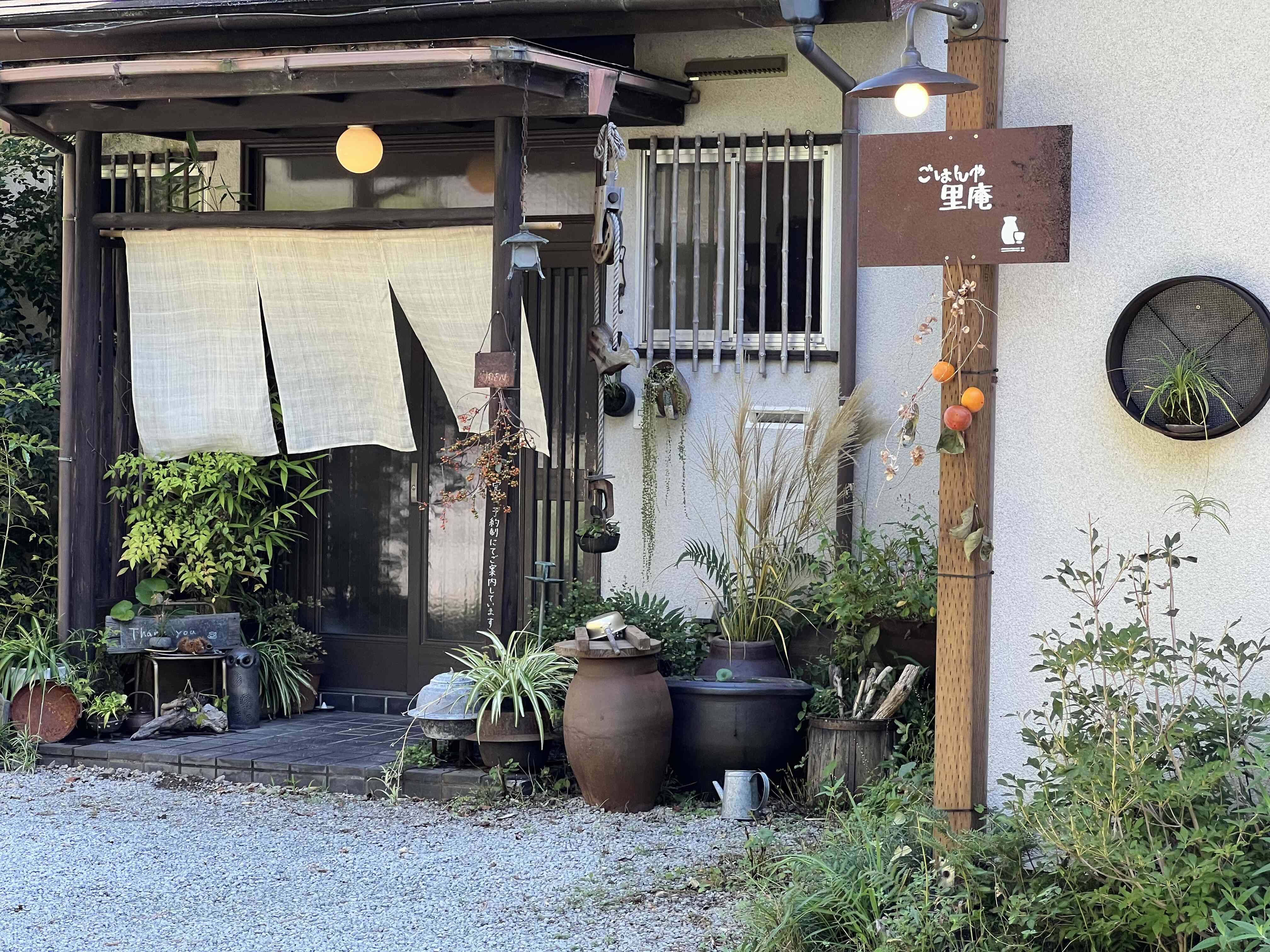 お山に囲まれ、季節折々の草花を楽しめる景観と古民家を再生した店内です。