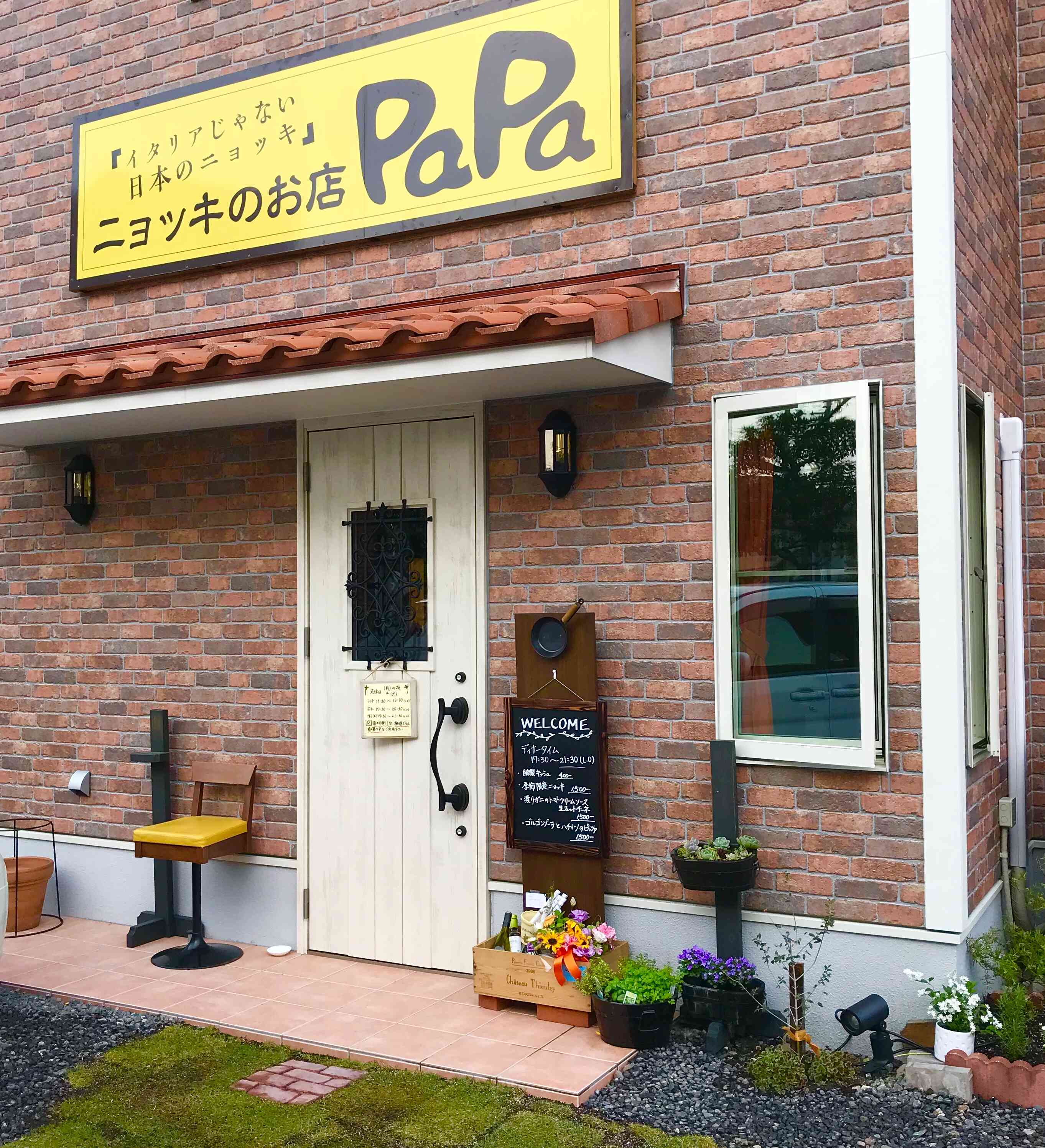神明ボウル様の目の前にあるレンガの外観、黄色い看板が目印。駐車場もございます