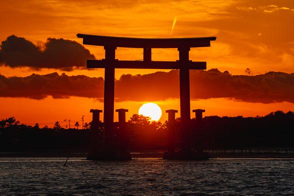 弁天島のシンボル・赤鳥居の中に夕日が沈む神秘的な光景