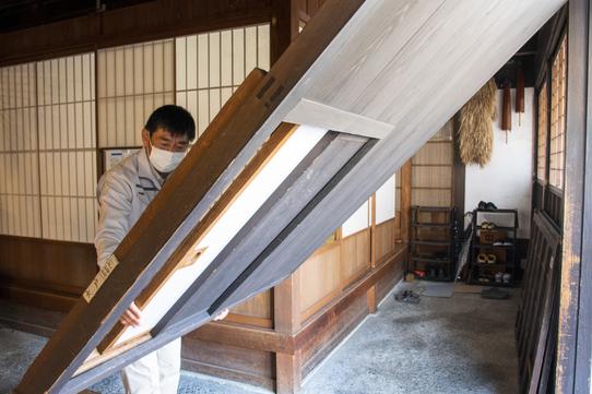 吊り大戸を開ける様子