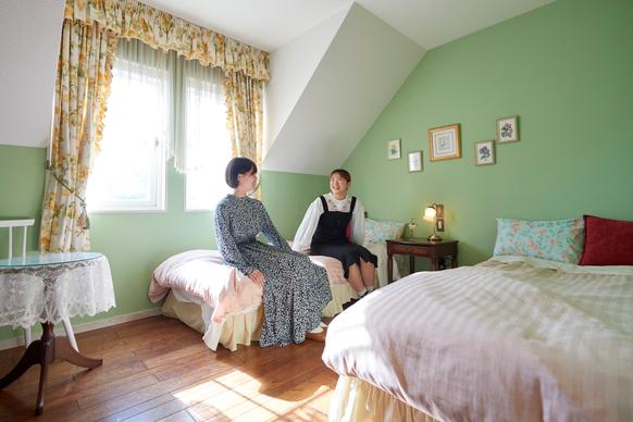 グリーンの壁紙が可愛い201号室。パリのアパルトマンをイメージした屋根裏部屋風のお部屋は、南向きの窓からガーデンが見下ろせ、明るい陽射しが差し込みます